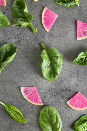 Flat lay composition with fresh sliced radish and leaves on gray backgroundの写真素材
