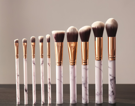 Makeup brushes for applying decorative cosmetics on wooden tableの写真素材