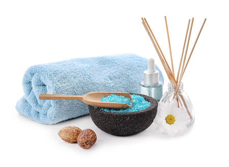 Beautiful spa composition with towel and sea salt on white background