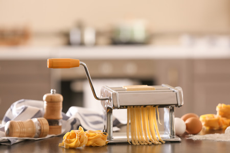 Pasta maker and products on kitchen tableの写真素材