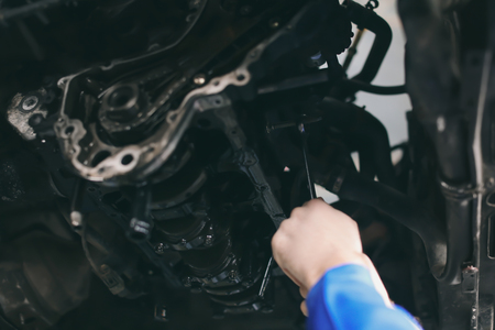 Male mechanic fixing car in service centerの写真素材
