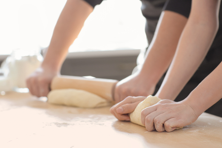 Bakers preparing dough on kitchen tableの写真素材
