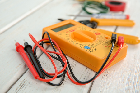 Multimeter on wooden table. Electrical tools