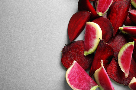 Ripe sliced beet and radish on gray background, top view