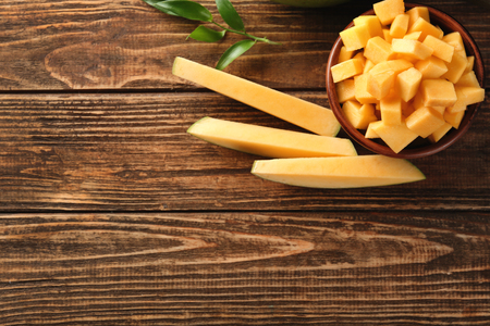 Cut ripe mango on wooden backgroundの写真素材