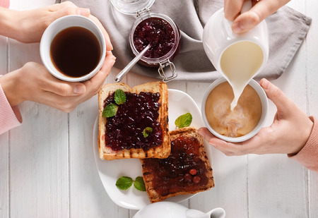Women drinking tea with milk and delicious toasts, top viewの写真素材