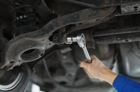 Male mechanic fixing car in service centerの写真素材
