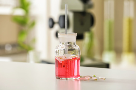 Flask with petals on table in laboratory