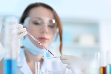 Scientist working with blood sample in laboratoryの写真素材