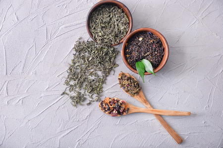 Flat lay composition with different types of dry tea leaves on light backgroundの写真素材