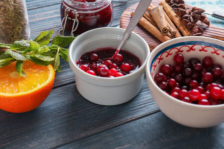 Bowl with delicious cranberry sauce and products on tableの写真素材