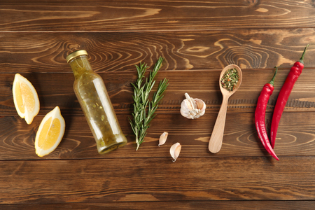 Composition with bottle of tasty sauce and condiments on wooden background, flat layの写真素材