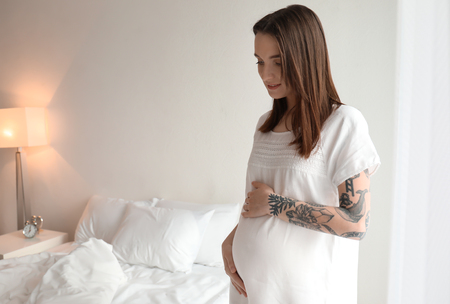 Beautiful pregnant woman at home in morningの写真素材