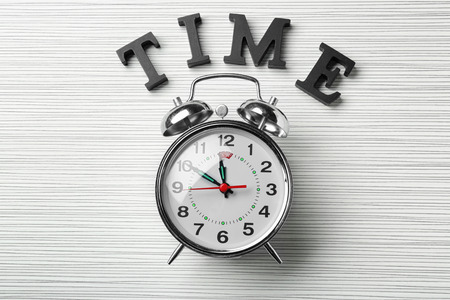 Alarm clock with word Time on table. Time management concept