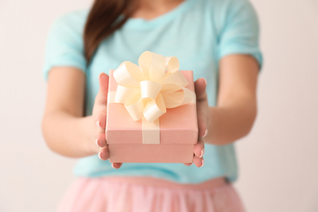 Beautiful young woman with gift box on color background, closeupの写真素材