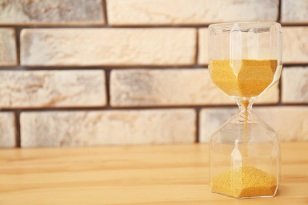 Hourglass on wooden table. Time management concept
