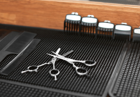 Trimmer attachment and scissors on table in hairdressing salon