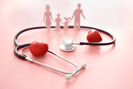 Family figure, red hearts and stethoscope on color background. Health care conceptの写真素材