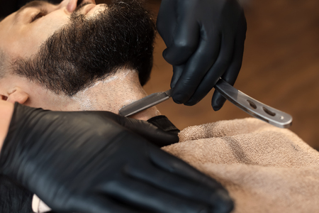 Professional barber working with client in hairdressing salonの写真素材