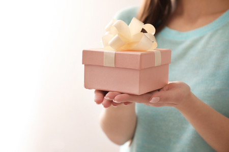 Beautiful young woman with gift box on color background, closeupの写真素材
