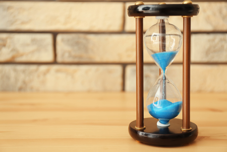 Hourglass on wooden table. Time management concept