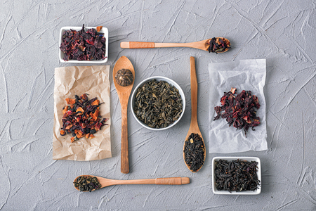 Flat lay composition with different kinds of dry tea on grey backgroundの写真素材