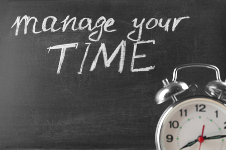 Alarm clock and chalkboard with phrase "Manage your time", closeupの写真素材
