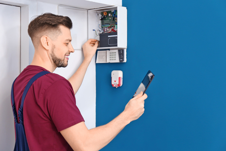 Electrician inspecting alarm system