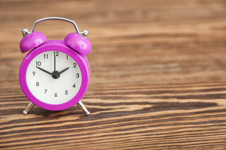Alarm clock on wooden table. Time management concept