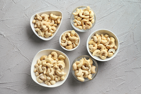 Bowls with tasty cashew nuts on light backgroundの写真素材