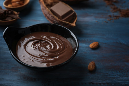 Bowl with molten chocolate on wooden tableの写真素材