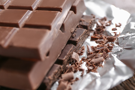 Delicious chocolate bars on foil, closeup