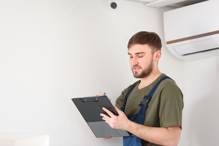 Electrician installing security camera indoorsの写真素材