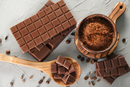 Composition with cocoa powder and tasty chocolate on gray backgroundの写真素材