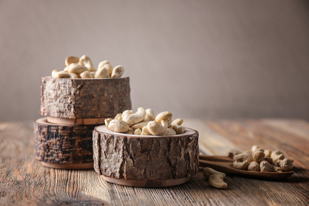 Bowls with tasty cashew nuts on wooden tableの写真素材