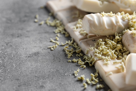 Delicious white chocolate on grey background