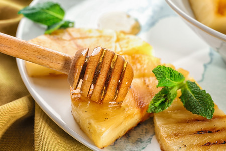 Grilled pineapple slices with honey on plate, closeupの写真素材