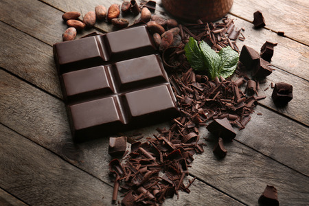 Chocolate bar with curls on wooden tableの写真素材