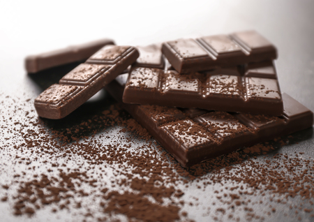 Tasty milk chocolate and cocoa powder on tableの写真素材