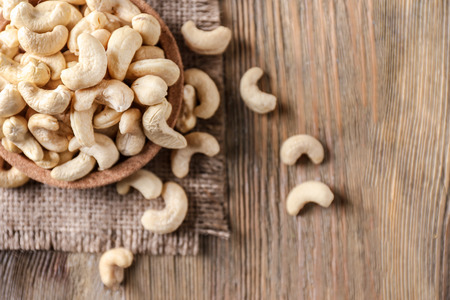 Plate with tasty cashew nuts on wooden tableの写真素材