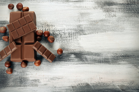 Tasty chocolate and hazelnuts on wooden background, top viewの写真素材