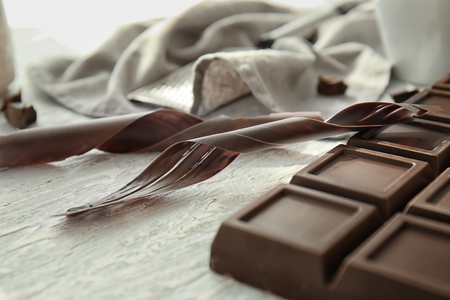 Delicious chocolate bar and shavings on table, closeupの写真素材