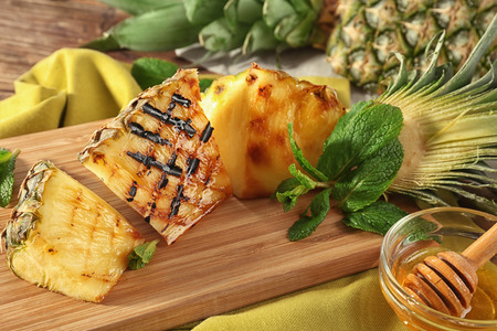 Grilled pineapple slices on wooden boardの写真素材