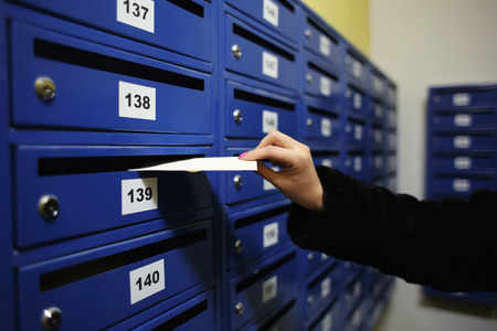 Woman putting letter into mailbox