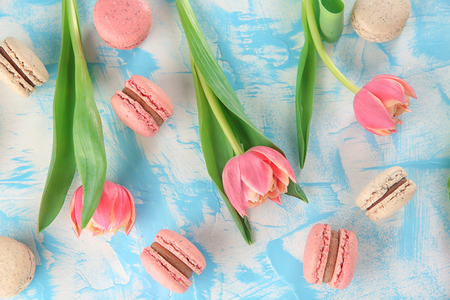 Flat lay composition with tasty macarons and tulips on color backgroundの写真素材