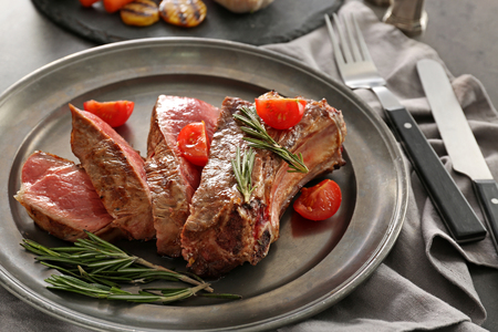 Plate with meat and vegetable garnish on tableの写真素材