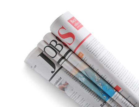 Folded newspapers with headline JOBS on white background
