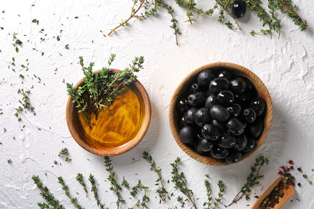 Bowls with black olives and oil on table, top viewの写真素材