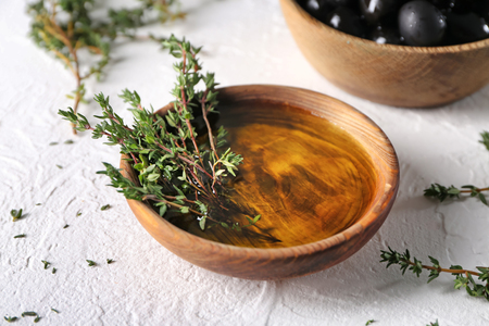 Bowl with olive oil and thyme on tableの写真素材