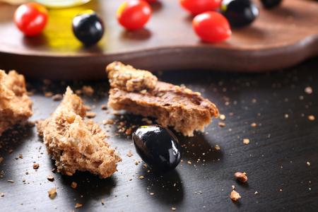 Black olive covered with oil and bread on tableの写真素材